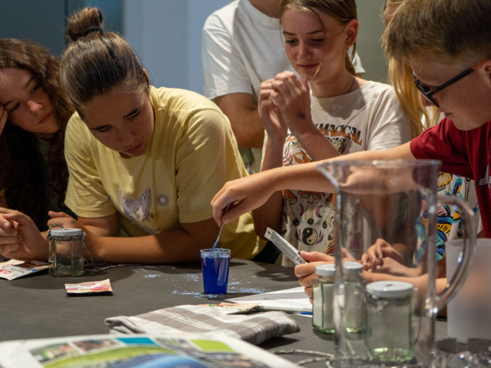 Kinder machen Experimente mit Wasser.