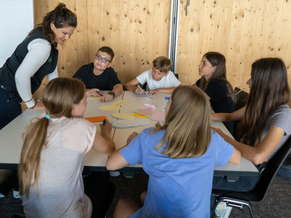 Ein Guide der Umwelt Arena instruiert die Kinder für den Wasser und Leben-Workshop